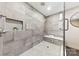 Modern walk-in shower with gray tile, built-in bench, and convenient niche for toiletries and decorative plants at 3661 Annlin Ave, Charlotte, NC 28209