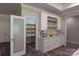 Butler's pantry featuring white cabinetry, open shelving, and a frosted glass door at 4531 Dry Run Rd, Fort Mill, SC 29708