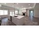 Open-concept living room features a kitchen island and a stone fireplace at 4531 Dry Run Rd, Fort Mill, SC 29708