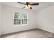 Bedroom with large window providing natural light and a ceiling fan at 5529 Seths Dr, Charlotte, NC 28269