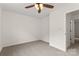 Bedroom features neutral carpet and paint, a ceiling fan, and open doorway to hall at 5529 Seths Dr, Charlotte, NC 28269