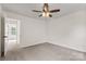 Bedroom features neutral carpet, a ceiling fan, and a doorway to another room at 5529 Seths Dr, Charlotte, NC 28269