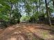 A backyard with tall trees and a wooden fence at 616 E Oakwood Ave, Albemarle, NC 28001