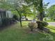 Well-maintained front yard featuring lush green grass, mature trees, and a charming flower bush at 616 E Oakwood Ave, Albemarle, NC 28001