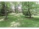 Backyard view of the home, surrounded by lush trees and greenery at 625 Saint Andrews Rd, Statesville, NC 28625