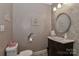 Elegant powder room with pedestal sink, decorative mirror, and tiled walls at 625 Saint Andrews Rd, Statesville, NC 28625