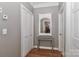 Hallway view featuring hardwood floors, neutral walls, a decorative mirror, and closet storage at 625 Saint Andrews Rd, Statesville, NC 28625