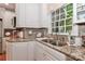 Bright kitchen features granite counters, tile backsplash, stainless steel sink and window with view to backyard at 625 Saint Andrews Rd, Statesville, NC 28625