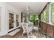 Enclosed porch featuring white wicker furniture, wood floors, and serene outdoor views at 625 Saint Andrews Rd, Statesville, NC 28625