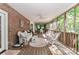 Inviting screened porch featuring brick wall, wicker seating, and peaceful outdoor views at 625 Saint Andrews Rd, Statesville, NC 28625
