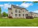 Expansive backyard featuring a deck, lush lawn, privacy fence, and the rear facade of the house at 6718 Heritage Orchard Way, Huntersville, NC 28078