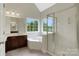Bright bathroom featuring a soaking tub, walk-in shower, and double window overlooking the yard at 6718 Heritage Orchard Way, Huntersville, NC 28078