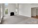 Bright and airy living room with a cozy fireplace, soaring ceilings and neutral carpeting at 6718 Heritage Orchard Way, Huntersville, NC 28078