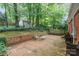 Brick patio features outdoor seating, with trees, garden bed, and shed in the backyard at 6749 Windyrush Rd, Charlotte, NC 28226