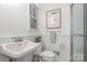 Classic bathroom with white wainscoting, vintage sink, and a glass-enclosed shower at 6749 Windyrush Rd, Charlotte, NC 28226