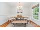 Cozy dining room features modern chandelier and a wooden dining table with bench at 6749 Windyrush Rd, Charlotte, NC 28226