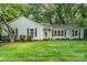 Charming single-story home with a lush green lawn and mature trees at 6749 Windyrush Rd, Charlotte, NC 28226