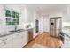 Updated kitchen showcasing stainless steel appliances, granite countertops, white cabinets, and hardwood floors at 6749 Windyrush Rd, Charlotte, NC 28226