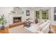 Bright living room boasts a brick fireplace, comfortable seating, and natural light through large windows at 6749 Windyrush Rd, Charlotte, NC 28226