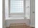 Bright bathroom features a soaking tub with tile accents and a privacy glass block window at 814 Settlers Dr, Cherryville, NC 28021