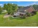 Aerial view of a brick house with a screened porch, patio, lush lawn, and landscaped garden at 814 Settlers Dr, Cherryville, NC 28021