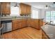 Well lit eat-in kitchen features wood floors, wood cabinets, and stainless steel dishwasher at 814 Settlers Dr, Cherryville, NC 28021