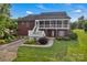 Rear of brick house with multiple porches, a patio and lush green landscaping at 814 Settlers Dr, Cherryville, NC 28021