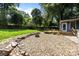 View of backyard area that features a wooden patio deck, stone landscaping and an outdoor fire pit at 917 Dent Ct, Charlotte, NC 28210