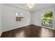 This bedroom features hardwood floors, two windows, white walls, and natural lighting at 917 Dent Ct, Charlotte, NC 28210