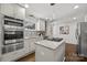 Well-lit kitchen featuring white cabinetry, a center island with gas cooktop, and stainless steel appliances at 917 Dent Ct, Charlotte, NC 28210