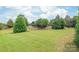 A large, lush green backyard with mature trees offering privacy and a wooden fence at 9710 Holden Ct, Charlotte, NC 28277