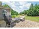 A well-manicured backyard featuring a stone patio and seating area with a grill and lush landscaping at 9710 Holden Ct, Charlotte, NC 28277