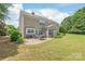 Backyard view featuring a patio with outdoor seating, a manicured lawn, and mature trees at 9710 Holden Ct, Charlotte, NC 28277