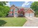 Two-story brick home featuring a well-manicured lawn and a two-car garage at 9710 Holden Ct, Charlotte, NC 28277