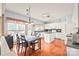 Bright eat-in kitchen boasts white cabinets, island, hardwood floors, and a large window with backyard views at 9710 Holden Ct, Charlotte, NC 28277