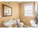 Cozy powder room with decorative mirror, pedestal sink, and natural light offers a functional space at 9710 Holden Ct, Charlotte, NC 28277