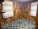 Small bedroom featuring unique wood paneling, patterned carpet, and curtains at 1014 Skyway Dr, Kannapolis, NC 28083