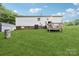 View of the rear of the house with a small wooden deck and large grassy yard at 103 Palace Pt, Kings Mountain, NC 28086