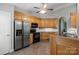 Kitchen with stainless steel refrigerator, stove, wooden cabinets, tile floors and a ceiling fan at 112 Chasse Ct, Cleveland, NC 27013