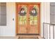 Close-up of an inviting front door, beautifully decorated with decorative wreaths and natural wood finish at 1134 Fincher Rd, Fort Lawn, SC 29714