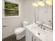 Modern bathroom featuring a vanity, toilet, decorative lighting and a window at 1212 Beechdale Dr, Charlotte, NC 28212