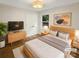 Cozy bedroom with light wood accents, a large window, and ample natural light, virtually staged at 1212 Beechdale Dr, Charlotte, NC 28212