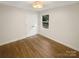 Bright bedroom with hardwood floors, a double closet, and a window offering plenty of natural light at 1212 Beechdale Dr, Charlotte, NC 28212