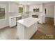 Modern kitchen with white cabinets, island, and stainless steel appliances at 1212 Beechdale Dr, Charlotte, NC 28212