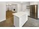 Open concept kitchen with island, stainless steel refrigerator, and view to living room at 1212 Beechdale Dr, Charlotte, NC 28212
