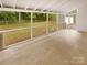 A covered screened porch offers a peaceful view of the backyard's lush greenery at 1212 Beechdale Dr, Charlotte, NC 28212