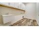 Functional laundry room with utility sink, built-in cabinets, and durable vinyl floors at 125 S Prestwick Way # 41, Mooresville, NC 28115