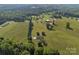 A captivating aerial view of the property featuring sprawling land, lush greenery, and a peaceful retreat at 130 Johnson Dairy Rd, Rockwell, NC 28138