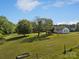 The back view of this property highlights the large backyard, playset, and mature trees at 130 Johnson Dairy Rd, Rockwell, NC 28138