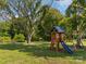 Backyard features a playset with a slide and swing set surrounded by lush greenery at 130 Johnson Dairy Rd, Rockwell, NC 28138
